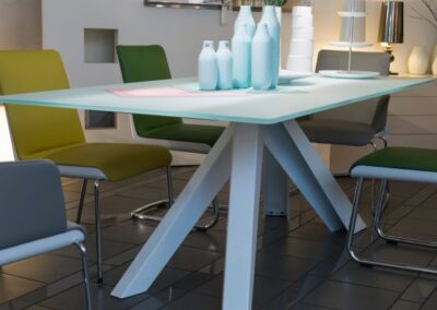 Blauer Glastisch mit grünen Stühlen